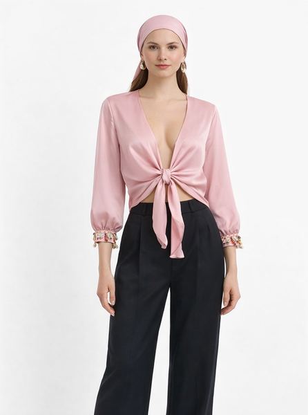 Pale rose Armani satin tie-front crop top with hand-applied shell and bead cuffs, worn with black wide-leg trousers — Bardees Riad Tie Crop (توب رياض).